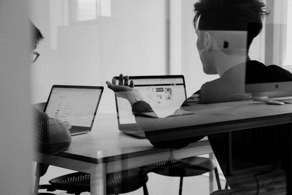 Zwei Personen besprechen Inhalte auf Laptops