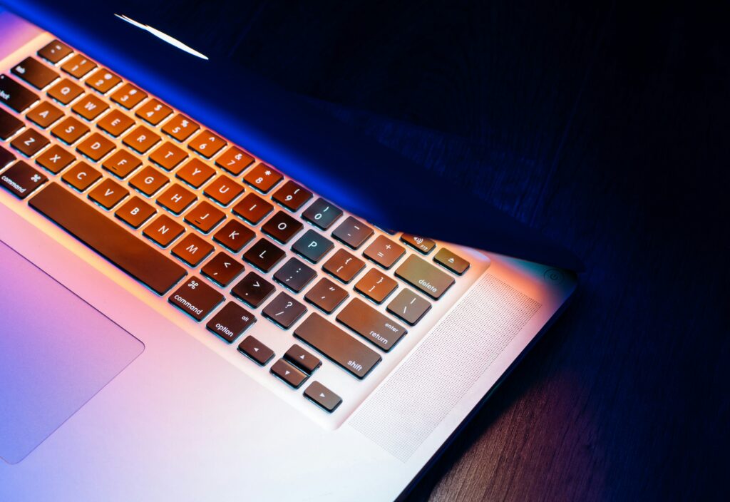 MacBook-Tastatur halb geschlossen mit buntem Licht